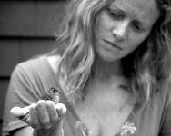 Black and white photo of a lady holding a bird in her palm