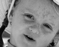 Black and white photo of a girl with sand on her face