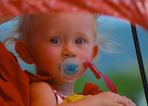 Photo of a baby under an umbrella in the summer heat